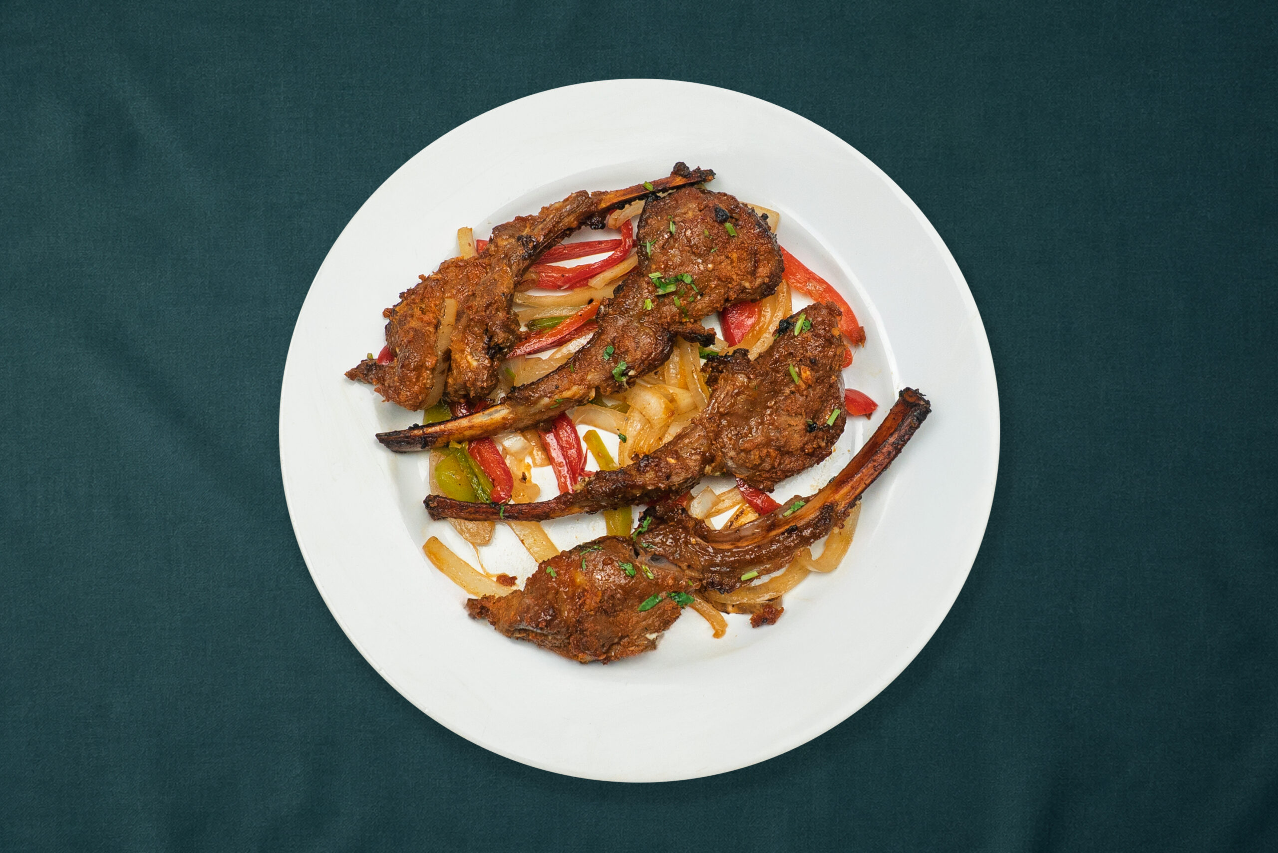Gochujang glazed lamb chops with peppers and onions