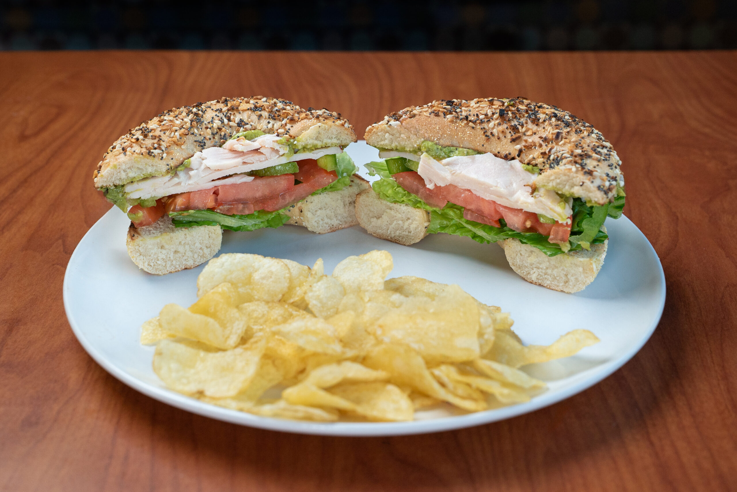 Holey Guacamole bagel sandwich with kettle chips — Denver deli food photography by AesthetiCo