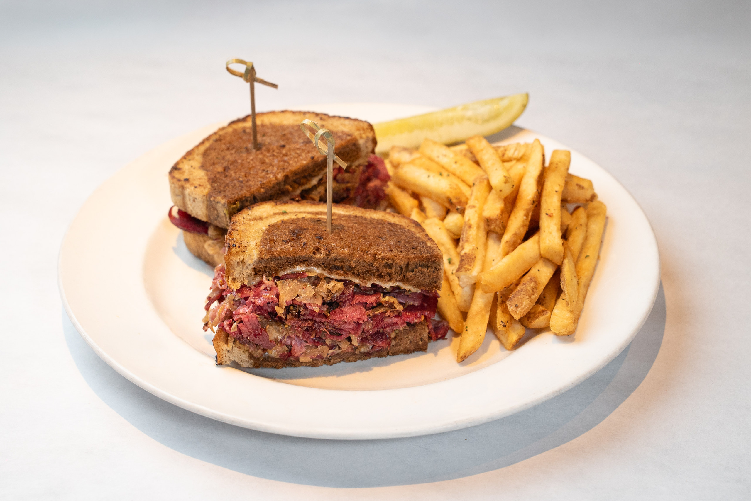 Reuben on grilled marble rye with fries and a pickle — Denver restaurant food photography