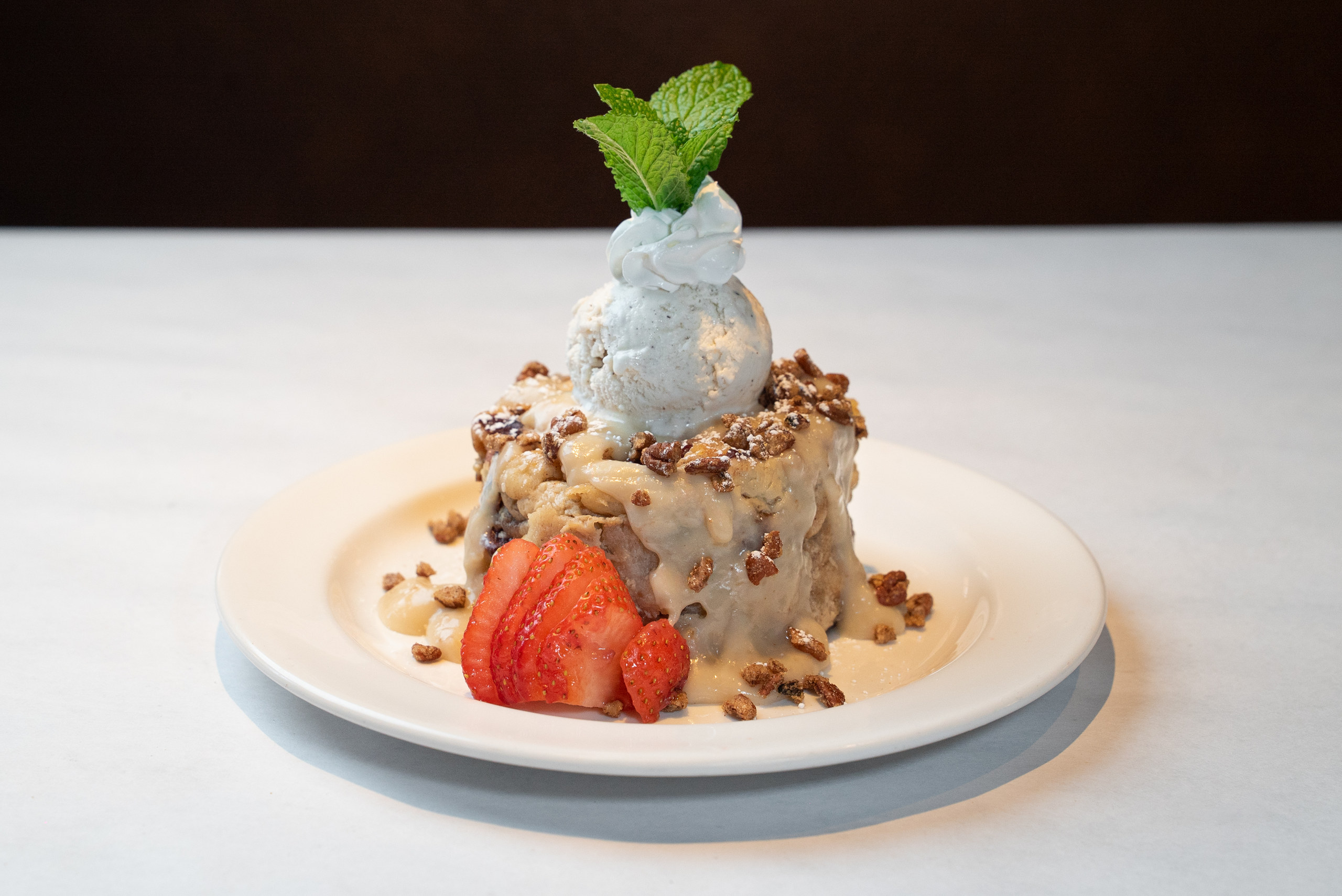 Whiskey bread pudding with candied pecans, vanilla ice cream and fresh mint — Denver food photography by AesthetiCo